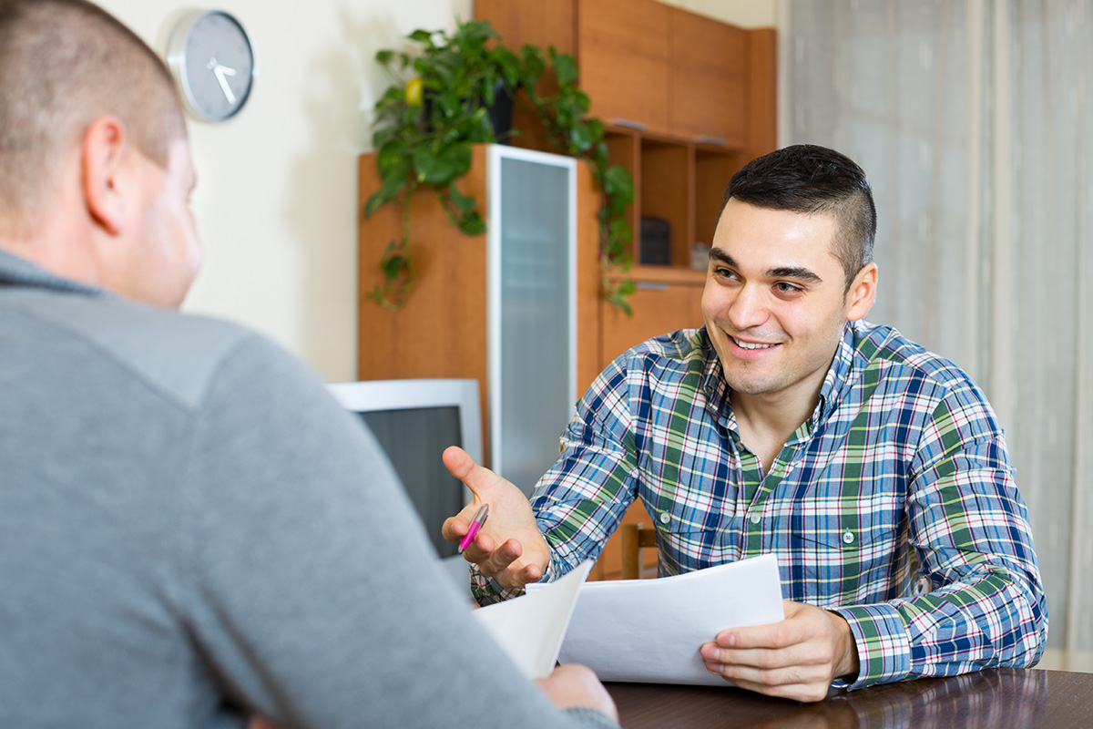 Ein Betreuer im Gespräch mit einem Menschen mit Autismus