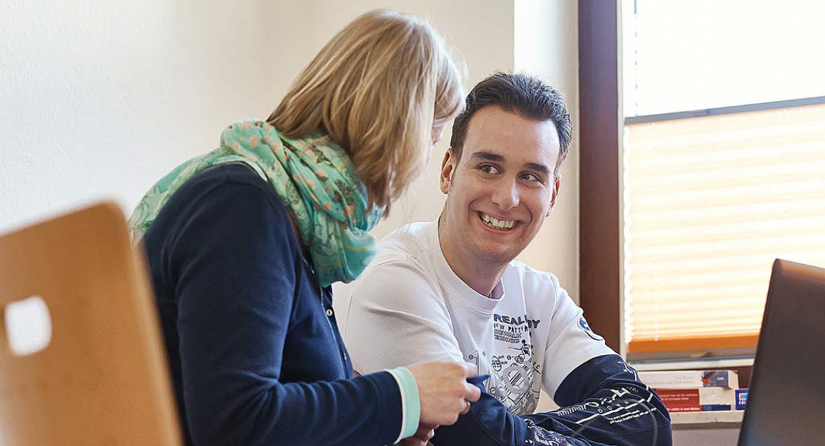 Ein Erwachsener bei der Autismus-Therapie mit einer Therapeutin