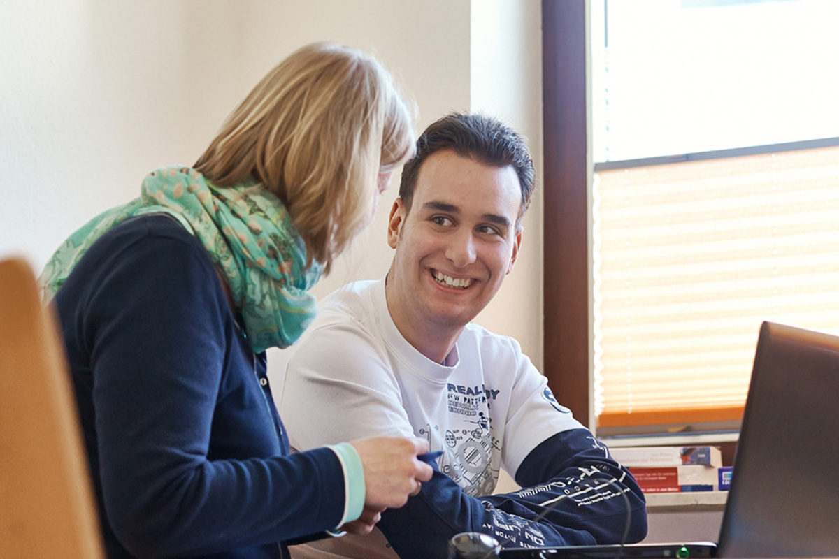 Ein Mann mit Autismus im Gespräch mit einer Therapeutin