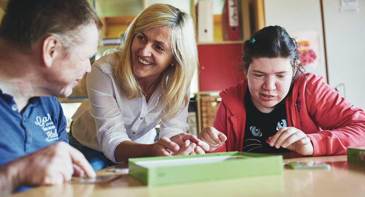 Eine Betreuerin mit zwei BewohnerInnen des Gemeinschaftlichen Wohnens