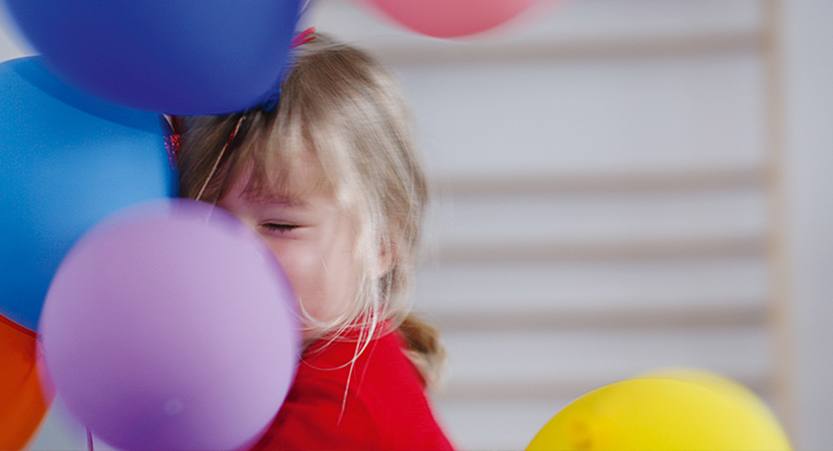 Ein Kind umarmt Luftballons