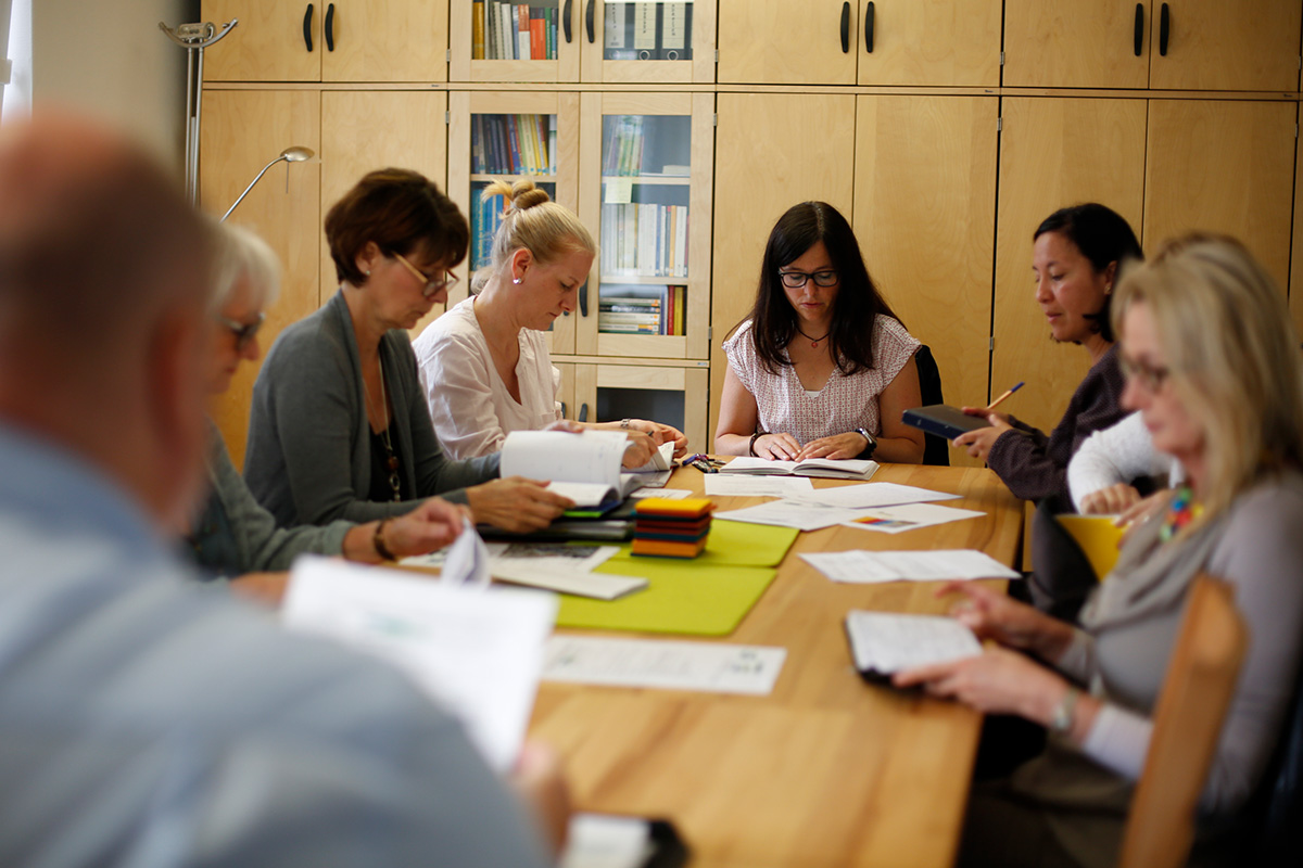 Mehrere Kolleginnen besprechen sich an einem Tisch